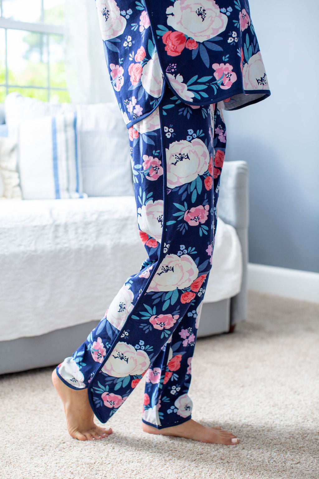 Dolphin hem pajama pants with elastic waistline and navy trim. Cream, red, and pink floral pattern. Match with big sister, big brother, Dad, and newborn.