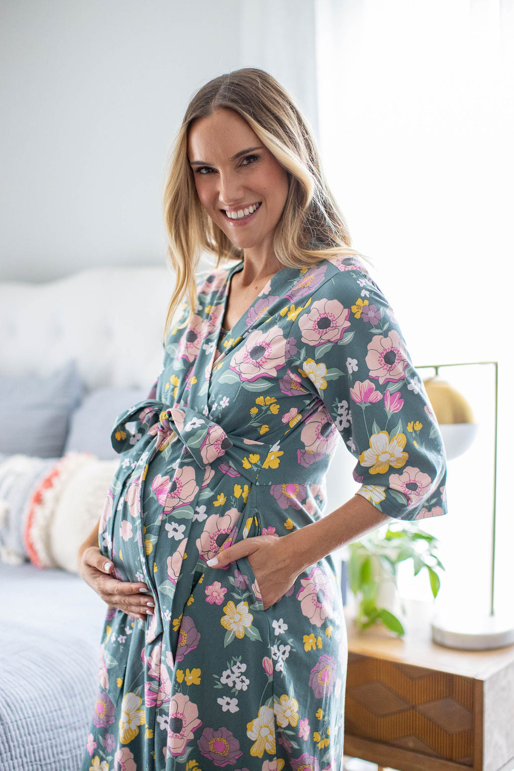 Charlotte maternity robe with pockets, belt closure, and knee length. Pink and yellow flowers against green background.